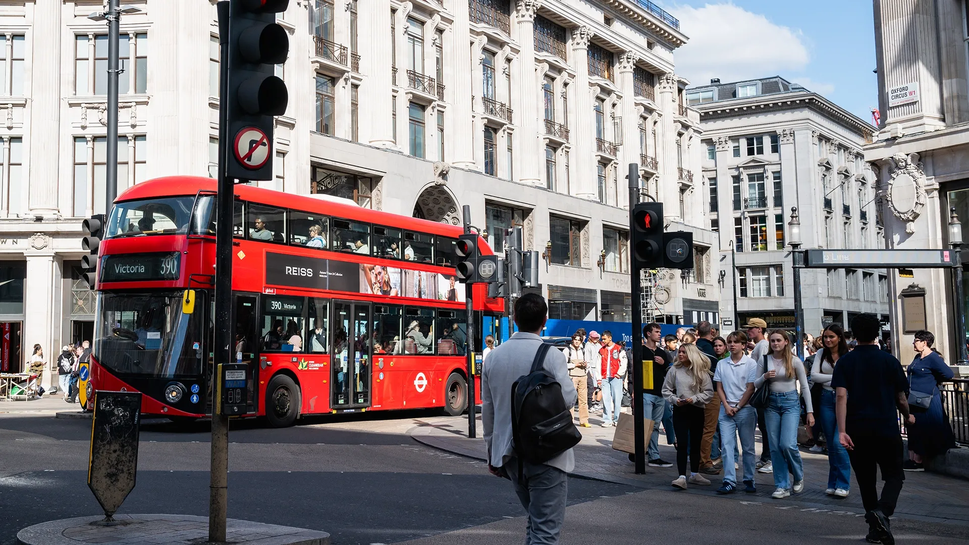 A superside bus advert for Reiss passes shopppers at Oxford Circus