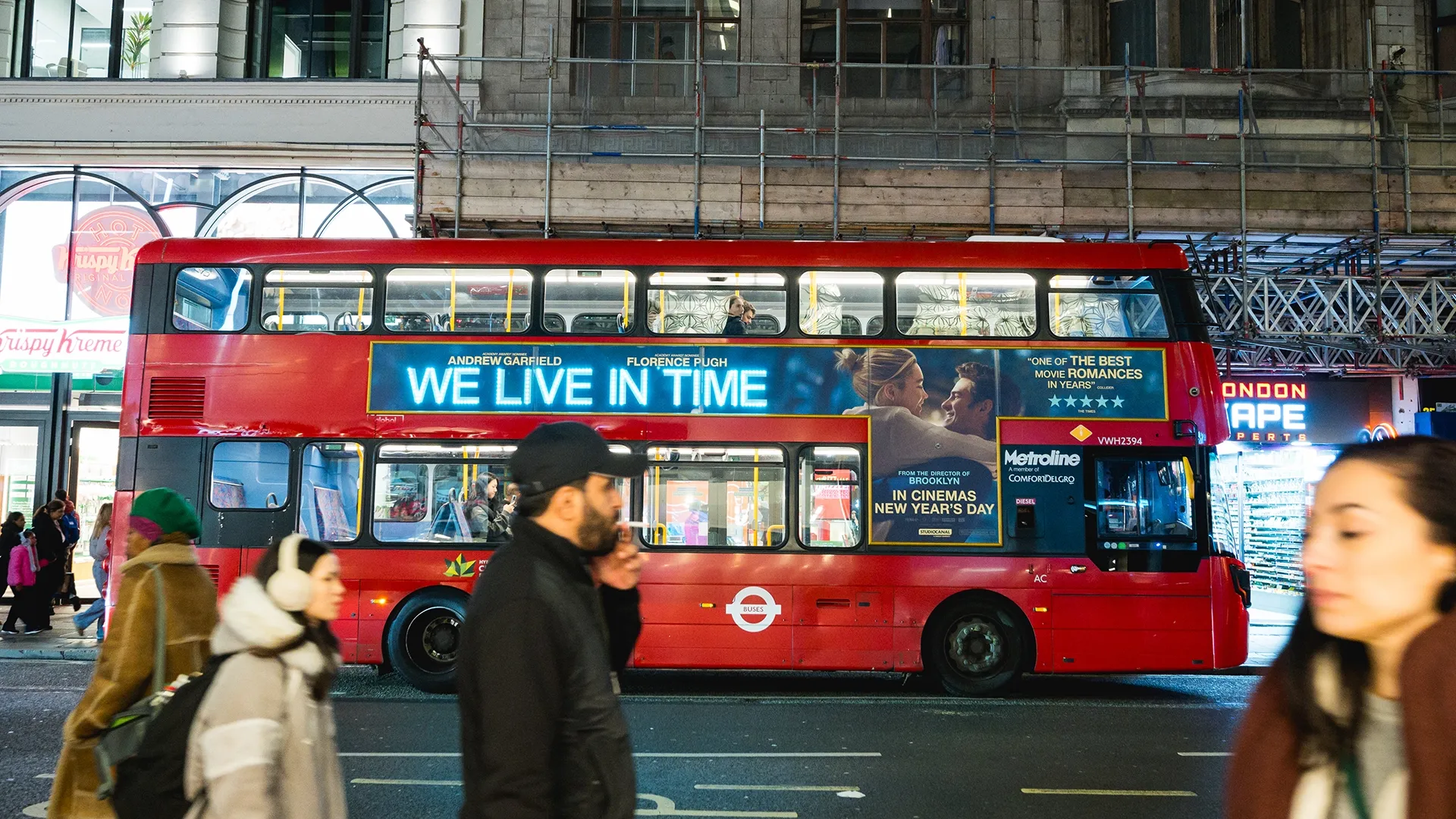 A busy London bus travelling across the city at night